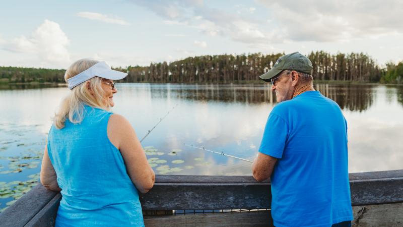 Couple fishing off of a dock.