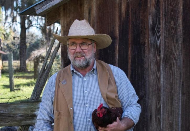 Park ranger Tony Ryan at Dudley Farm holding a chicken