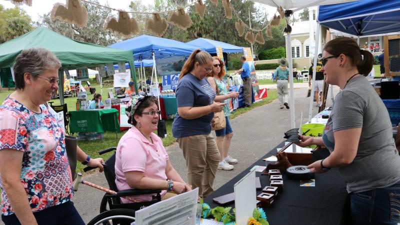 A state park volunteer at a booth, speaking with guests.