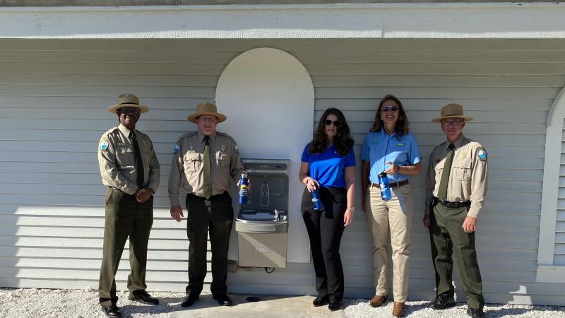 Officials pose for a photo with a refilling station at Honeymoon Island State Park. Left to right: BJ Givens, Bureau Chief, Chuck Hatcher, Director, Sharon Arollyo, Duke Energy Florida, Tammy Gustafson, Florida State Parks Foundation and Donald Bergeron, manager at Honeymoon Island State Park.